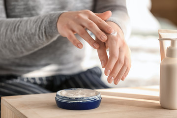 Woman applying natural cream onto skin, closeup