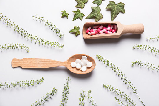 Different plant based pills on light background