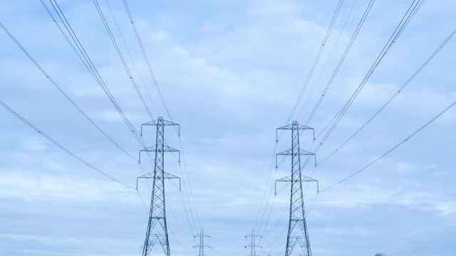 Timelapse of electricity pylons against a stormy sky themes of electricity