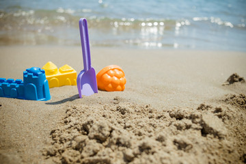 Bright plastic children's toys in the sand. Concept of beach recreation for children. Kid's summer games. Summer concept. copy space.family summer holiday at the seaside