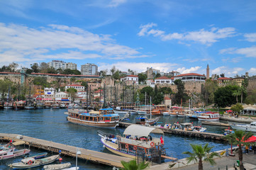 Fototapeta na wymiar Ships in the old harbour in Antalya (Kaleici), Turkey. Old town of Antalya is a popular Tourist destination in Turkey.
