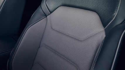 Leather car interior. Modern car illuminated dashboard. Luxurious car instrument cluster. Close up shot of automobile instrument panel. Modern car interior dashboard and steering wheel