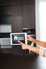 selective focus of female hands with digital tablet with smart home illustration