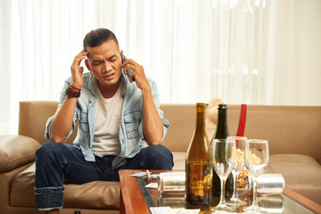 Man with headache calling friend