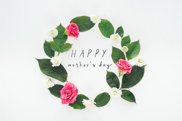 top view of circular composition with green leaves, roses and chrysanthemums on white background with happy mothers day illustration