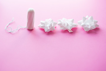 Medical female tampon on a pink background. Hygienic white tampon for women. Cotton swab. Only one tampon on a pink background. copy space