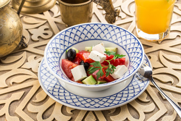 tomato salad with feta cheese and herbs on oriental table