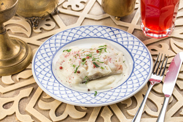 White fish fillet baked with white sauce on oriental table