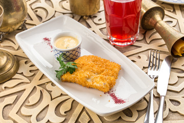 delicious golden batter deep fried fish fillets served on white plate on oriental table