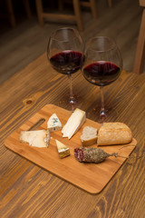 Red wine and assorted cheese plate with sausage