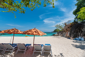 Umbrella with sunbed on the white beach in tropical sea