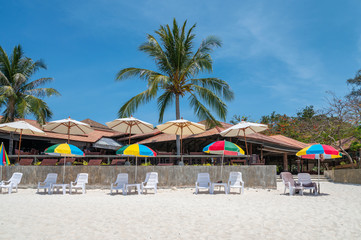 Colorful umbrella with sunbed on white beach