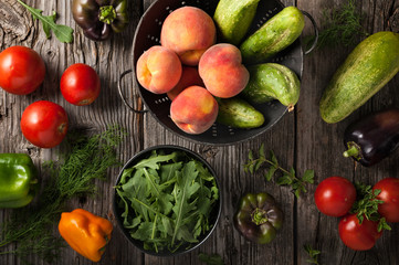 Freshly harvested fruits, vegetables and herbs on a wooden surface.