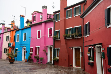 Fototapeta na wymiar Geometry of windows and doors in the colorful houses of the island of Burano, Venice, Italy Features old multicolored houses.