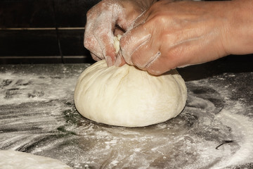 Traditional Caucasian cuisine. Elderly woman cooks  Ossetian pies. Preparing dough. Filling from leaves of beet and Ossetian cheese. Close up. Selective focus.