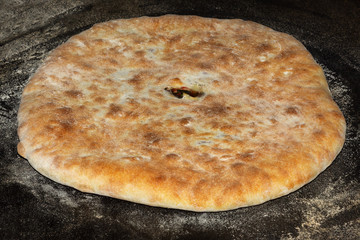 Traditional Caucasian cuisine. Ossetian pies.  Filling from leaves of beet and Ossetian cheese. Close up. Selective focus.