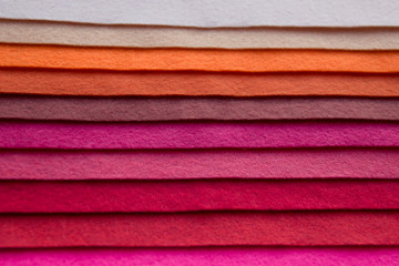  Fan of colored bright felt textile material. Brown, red,orange,purple, grey, yellow and pink color composition. Colorful felt texture for background with copy space. Felt fabric sheets