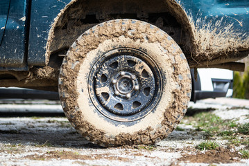 Fototapeta na wymiar Muddy dirty offroad terrain vehicle overland wheel