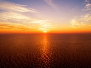 Obraz premium Aerial view of a Sunset sky background. Aerial Dramatic gold sunset sky with evening sky clouds over the sea. Stunning sky clouds in the sunset. Sky landscape. Aerial photography.