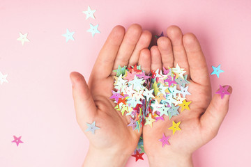 Gold glitter stars on children's hands.