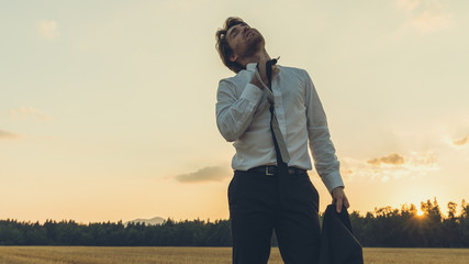 Exhausted businessman standing in nature