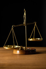 vintage golden scales on wooden table isolated on black