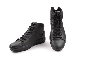 men's black leather shoes and a black camera on a black background. Copy space.