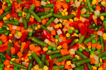 Sliced vegetables, corn, beans, peas, carrots, sweet peppers background.