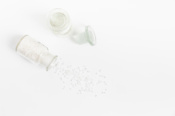 Pure Natural Coarse Sea Salt Spilling Out of A Vial On White Background