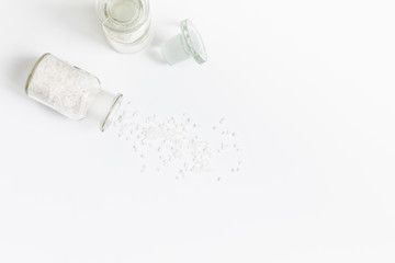 Pure Natural Coarse Sea Salt Spilling Out of A Vial On White Background