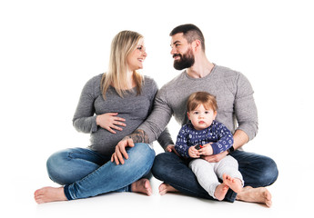 A beautiful happy family with a pregnant mother, the father and a son together