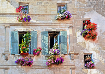 Fototapety  Typowa fasada starego prowansalskiego domu retro z oknami i drewnianymi okiennicami ozdobionymi kolorowymi świeżymi kwiatami w Prowansji, Lazurowe Wybrzeże, Francja