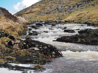 River Tavy water cascading over black lichen covered rocks through the Tavy Cleave gorge, Dartmoor National Park, Devon, UK