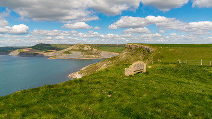 Stone bench at the South West Coast Path with a view over the Jurassic Coast and Emmett's Hill, near Worth Matravers, Jurassic Coast, Dorset, UK