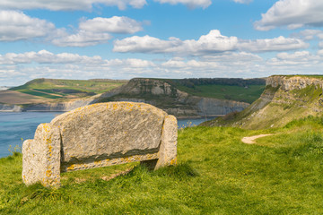Stone bench at the South West Coast Path with a view over the Jurassic Coast and Emmett's Hill, near Worth Matravers, Jurassic Coast, Dorset, UK