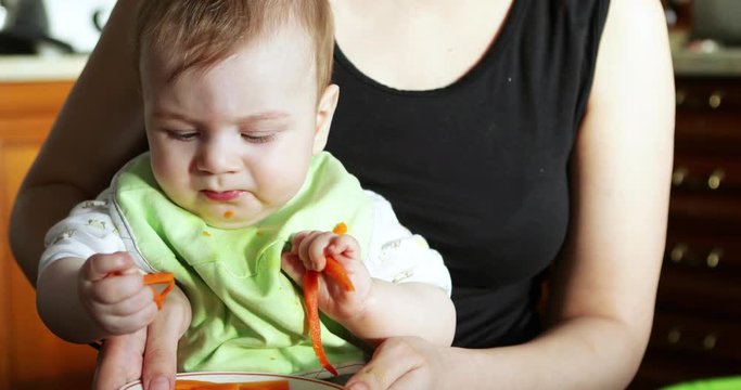 Baby boy eating a carrot