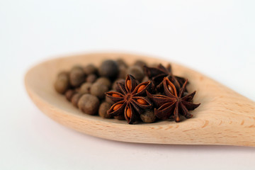 Anise and pepper on plate isolated on white.