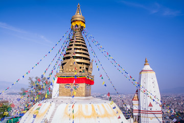 Swayambhunath or Monkey temple is an ancient religious architecture atop a hill in the Kathmandu Valley with a clear blue sky from Swayambhu, west of Kathmandu City, Nepal , March 2019