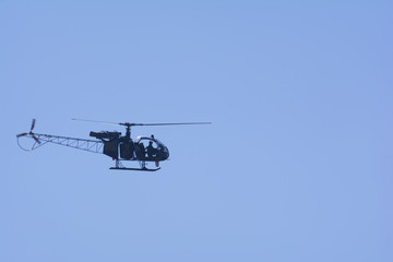 A small helicopter flying in the sky