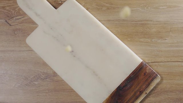 Potatoes fall in slow motion to the rock board on the table, falling vegetables, food in super slow motion, table top240fps Full HD