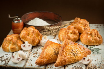 Puff pastry with champignon mushrooms up on a wooden table