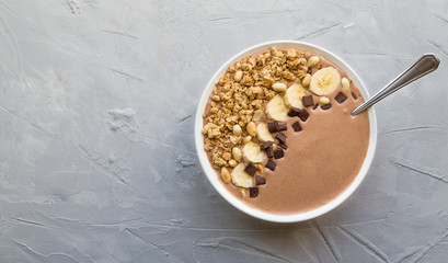 Chocolate smoothie bowl with bananas, granola and peanuts