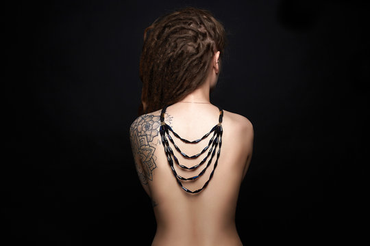 naked Girl with tattoo and necklace on her back