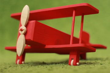 red biplane on green grass