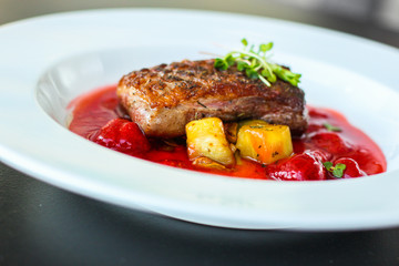 duck breast, vegetables, berry sauce and microgreen (main dish). food background. top view