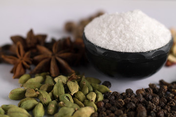 salt and cardamom on white background