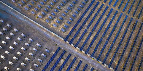 Aerial slanting single-axis solar photovoltaic panel under the illumination of the setting sun