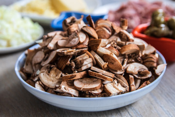Sliced brown champignon mushrooms in a ceramic bowl
