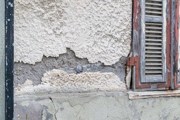 Naklejka premium Eine beschädigte Hausmauer und abgeplatzter Außenputz mit einem großen Loch, Deutschland