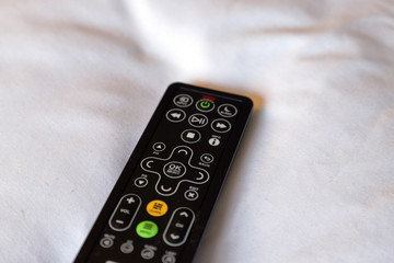 Hotel room remote control on white bedding